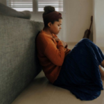 Yorkshire Counselling Services - a-black-lady-sitting-on-her-bedroom-floor-feeling-depressed