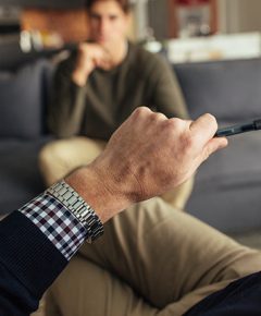 Hands of psychologist holding a pen and listening to man during therapy session. Psychotherapist understanding problems of a male patient.