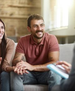 Young happy couple talking about their love with a marriage counselor at home.